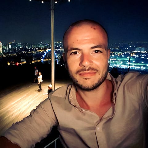 Alessandro De Blasis, on a rooftop above a city skyline at night
